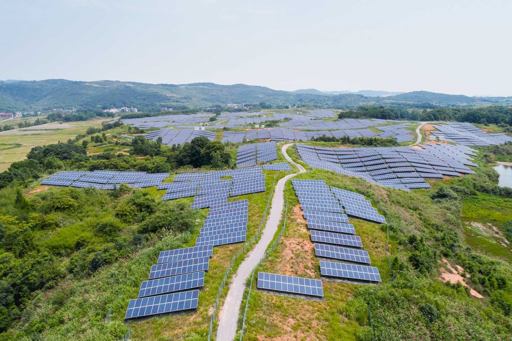 solar power plant on hillside, aerial view of clean energy in mountainous area